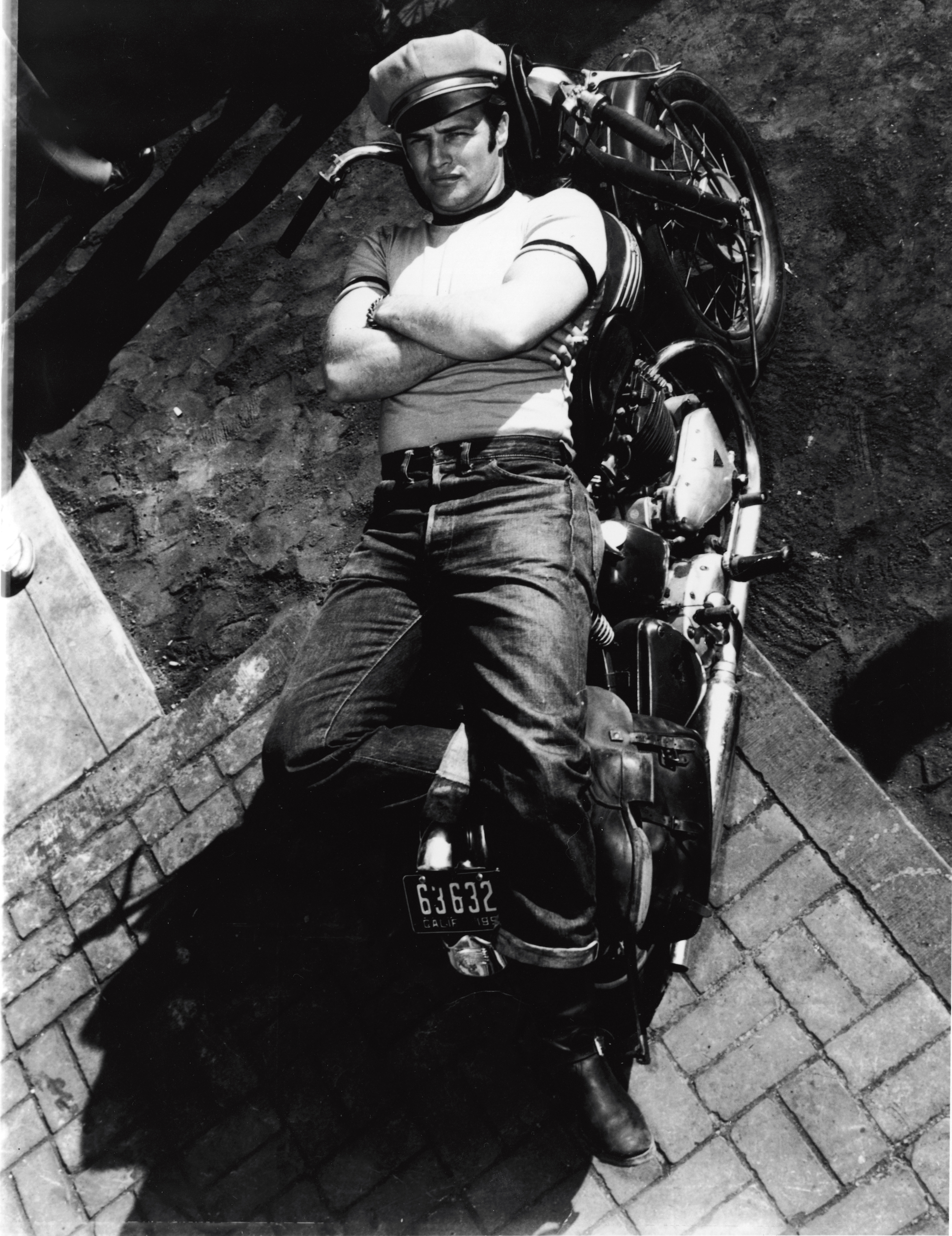 American actor Marlon Brando (1924 - 2004) lies on a motorcycle in a publicity shot for the film 'The Wild One,' directed by Laszlo Benedek, California, 1953. (Photo by Columbia TriStar/Courtesy of Getty Images)